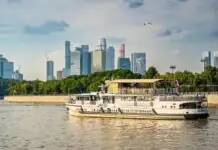 Москва-река, прогулочный теплоход и небоскрёбы «Москва-Сити» в ясный летний день